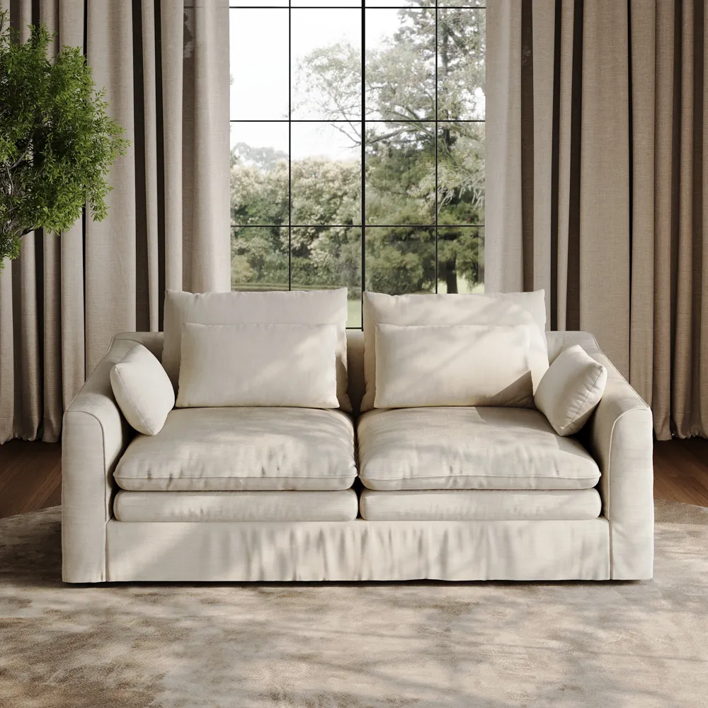 Olive green curved modular sofa in a modern living room with neutral walls, large windows, and sculptural floor lamp