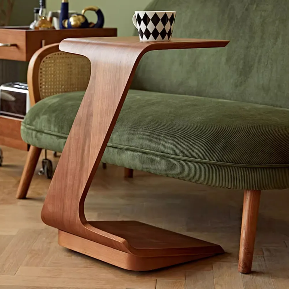 ● Modern Minimalist Cherry Wood Veneer Side Table with smooth curved design, placed beside a green velvet sofa in a warm and stylish mid-century inspired room