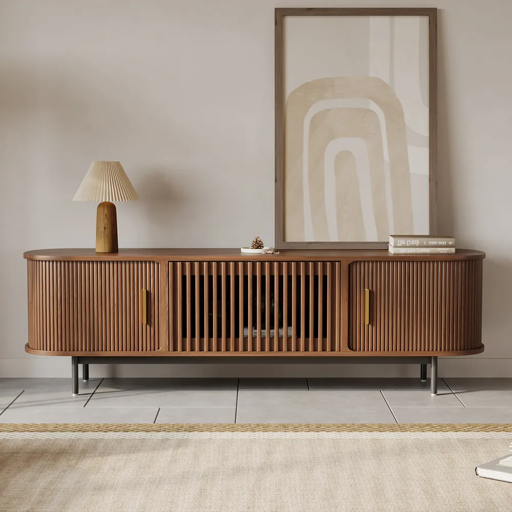 Close-up of a walnut slatted TV stand with sliding doors and minimalist metal legs in a contemporary interior.