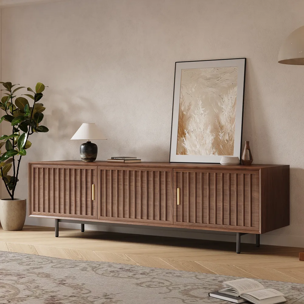 Mid-century modern walnut TV stand with fluted doors and brass handles, styled with abstract artwork and minimalist decor in a neutral living space