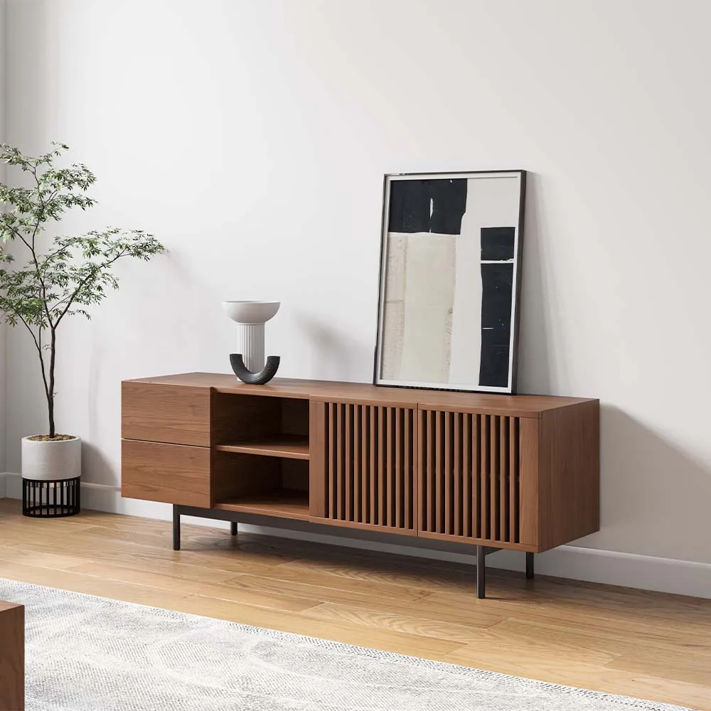Modern walnut TV stand with slatted doors and open shelves, styled with minimalist decor and abstract art in a light-filled room.