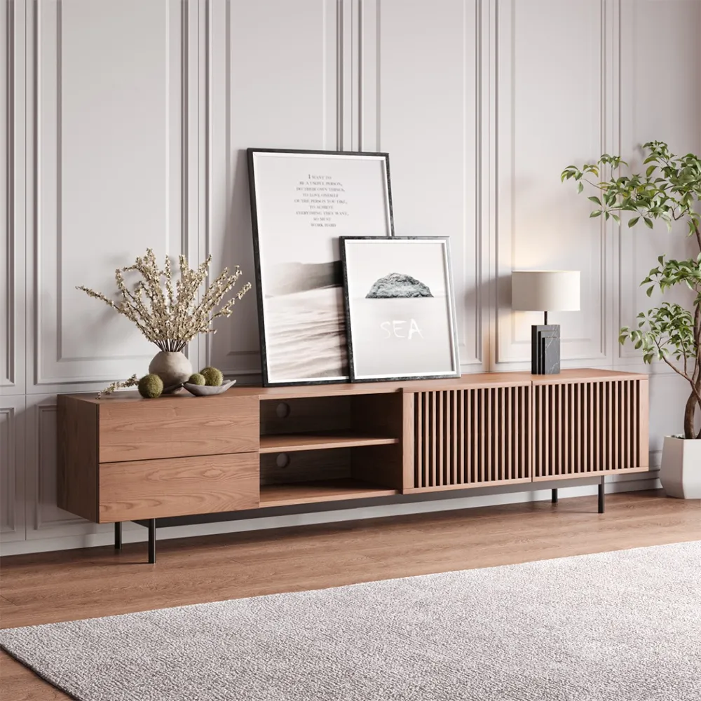 Mid-century modern wood TV stand with slatted doors and open shelving, styled with framed artwork and indoor plants.