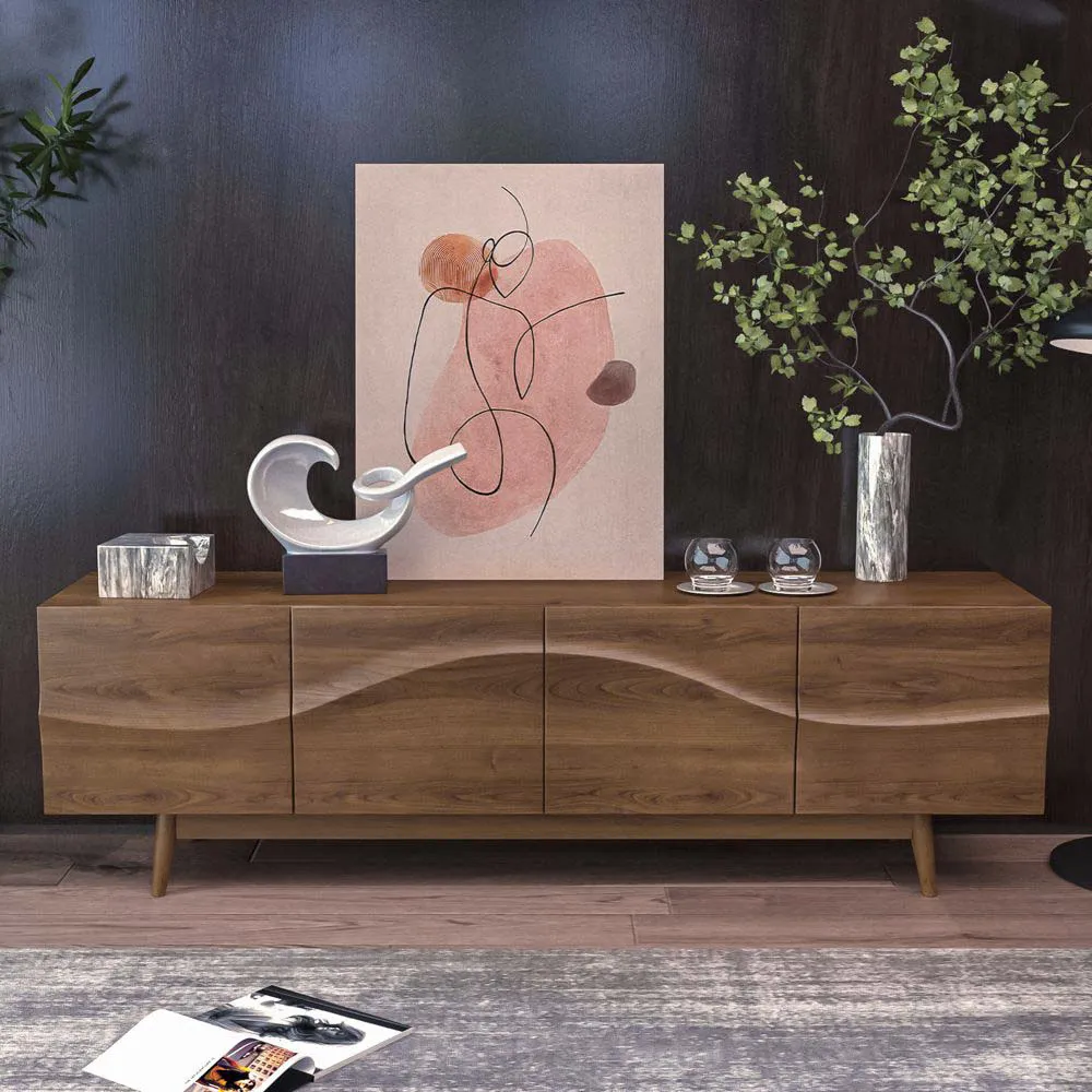  Walnut wood TV console with artistic wave-shaped cabinet fronts, styled with abstract wall art, sculptural decor, and greenery in a dark-accented room.