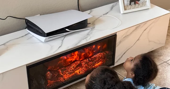 Children watching LED flame effect on modern electric fireplace TV stand with white marble finish in a cozy home setting