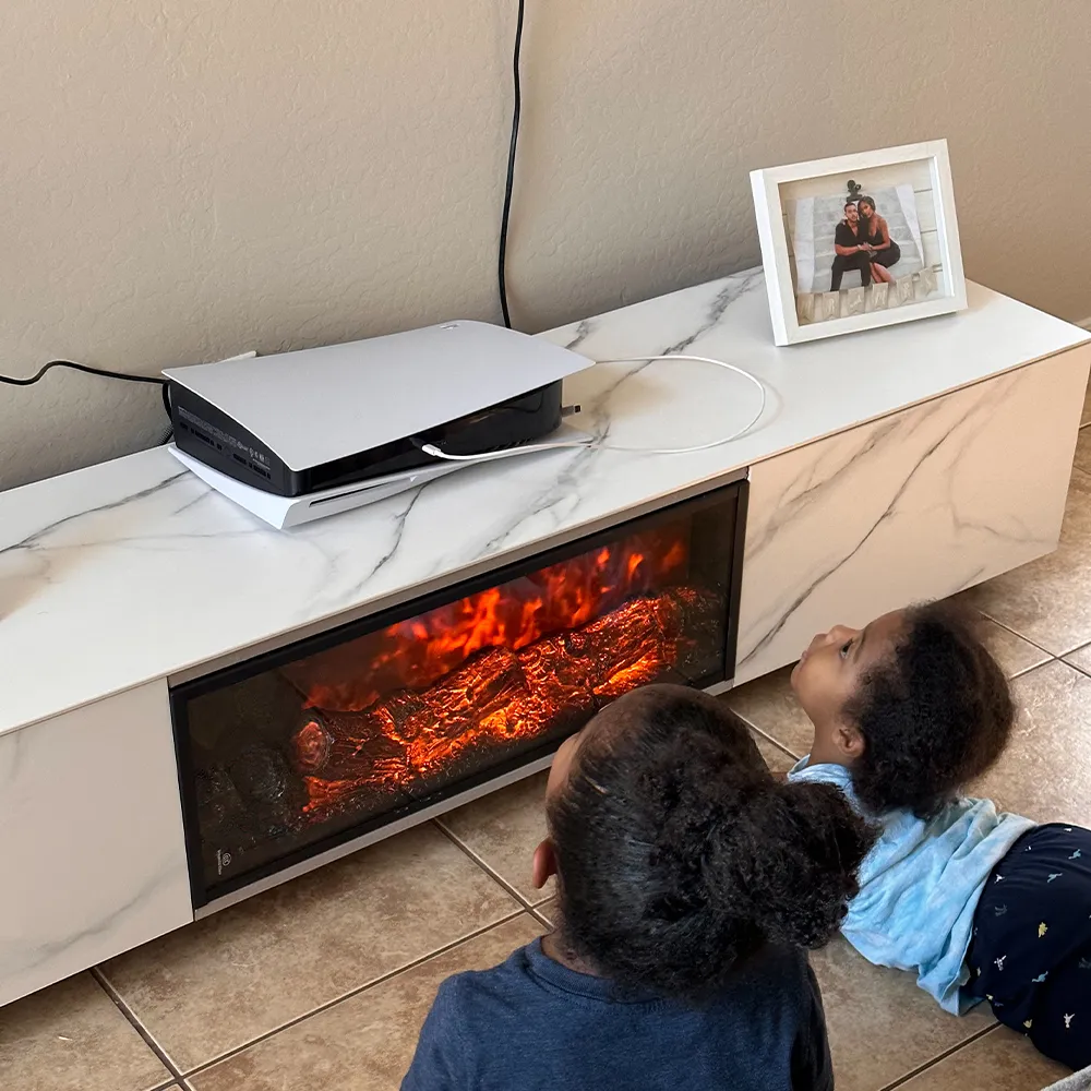Children watching LED flame effect on modern electric fireplace TV stand with white marble finish in a cozy home setting