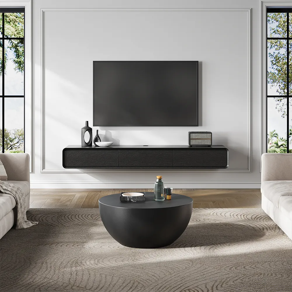 Modern minimalist floating TV stand with matte black finish in a bright living room, paired with a round coffee table and wall-mounted TV