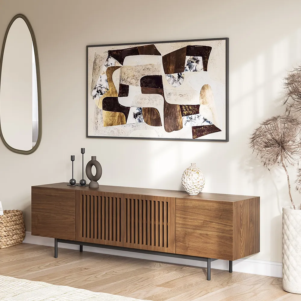 Mid-century modern wooden TV stand with slatted doors and black metal legs, styled with abstract wall art and decorative vases in a cozy living room.
