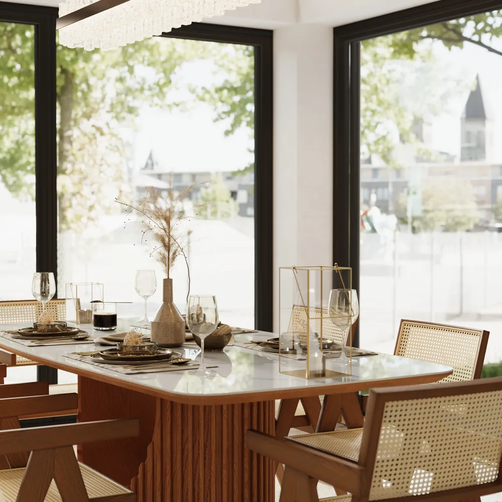Contemporary dining area with a white stone-top table, wood base, and woven back chairs, styled with minimalist neutral table decor and large city-view windows