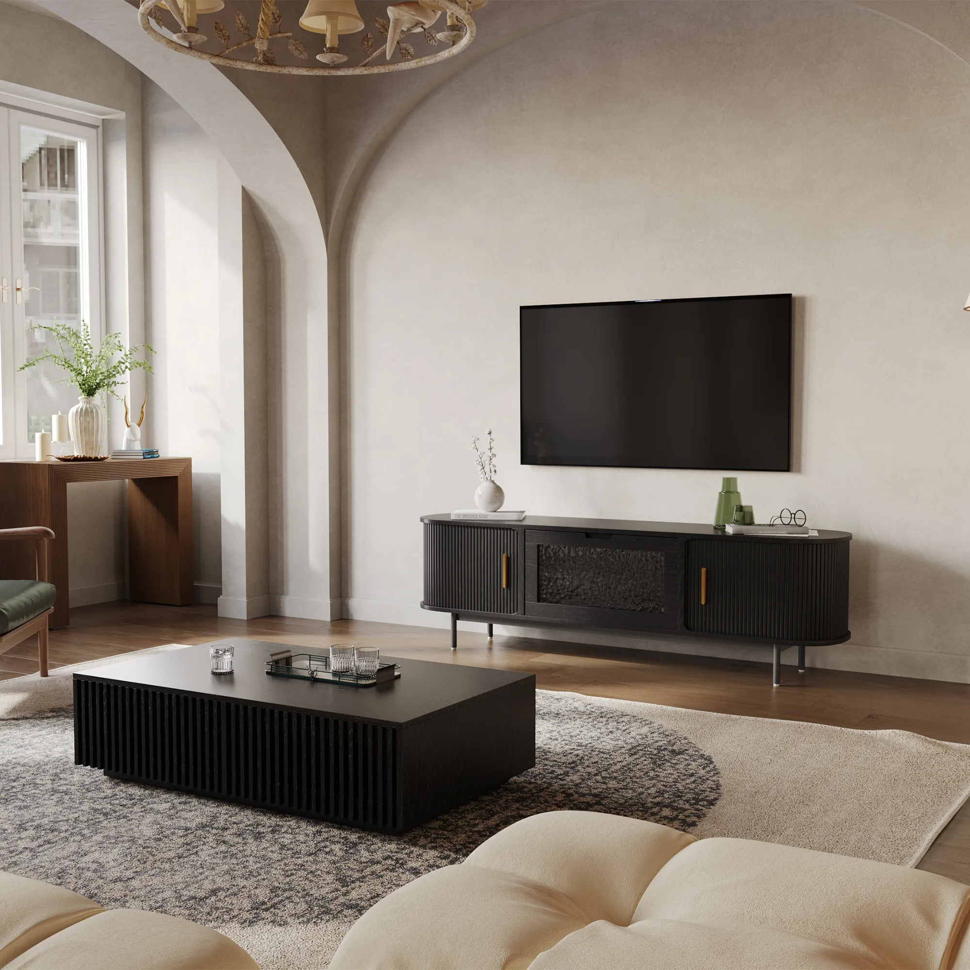 Black fluted TV console with glass panel and brass handles, styled in a high-ceilinged living room with arched architecture and modern decor.