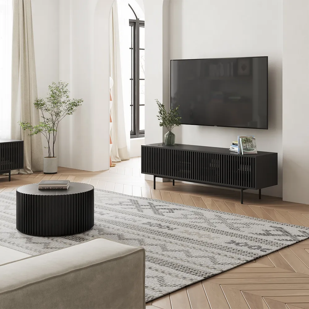 Modern black slatted TV stand in a bright living room with mounted flat screen and minimalist decor