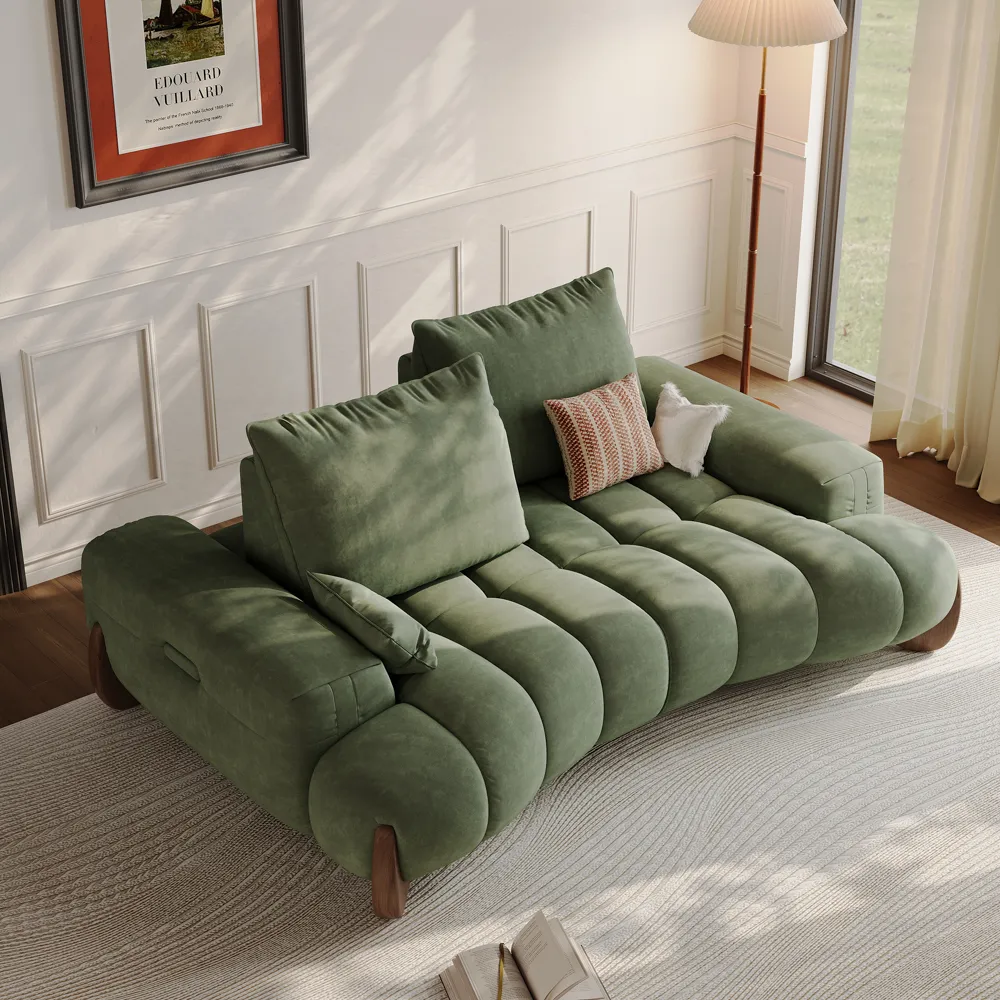 Oversized deep seat green corduroy modular loveseat with sculptural design, plush cushions, and wood legs in a sunlit modern living room.