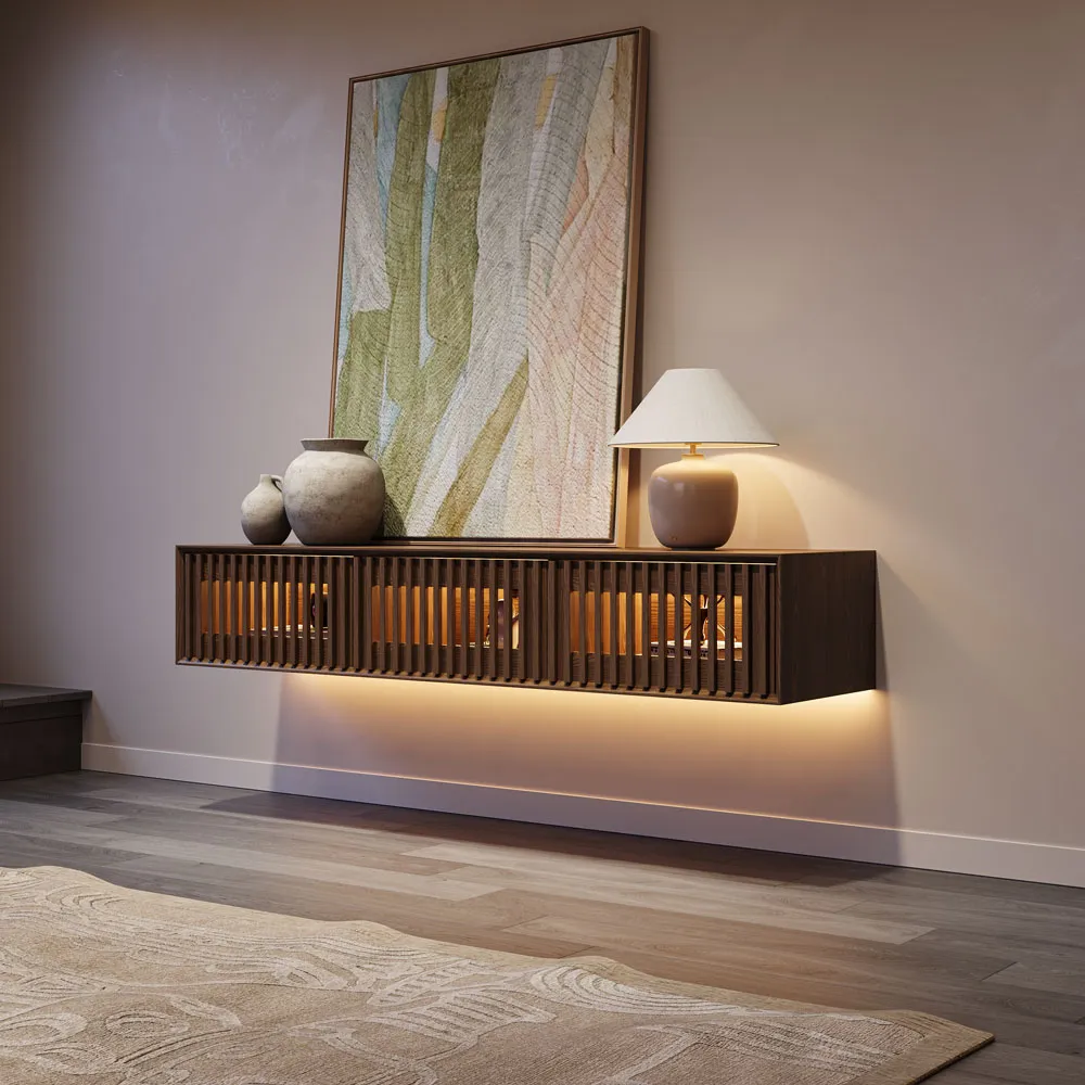 Side view of a mid-century style floating TV console with vertical slatted doors, wall-mounted under framed art and softly lit by adjustable LED lights