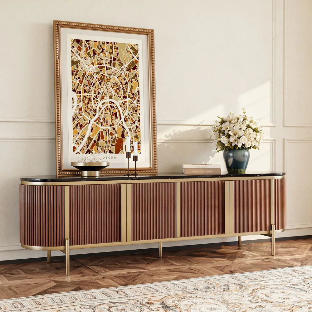 Elegant modern TV stand with fluted wood doors and black stone top, styled in a classic interior with framed art and floral decor on parquet flooring