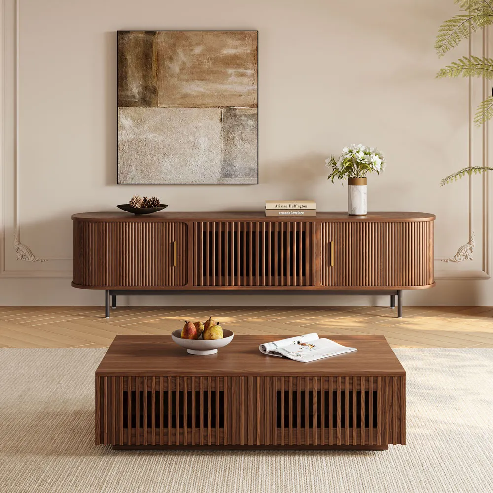 Mid-century modern wood coffee table and curved slatted TV console in a bright neutral-toned living room with artwork and flowers