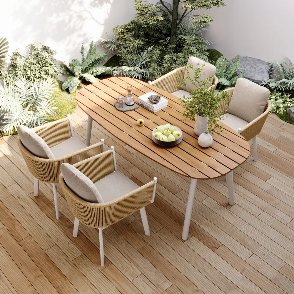 Outdoor dining set with teak slatted table and rope-woven armchairs, surrounded by lush greenery on a wood deck.