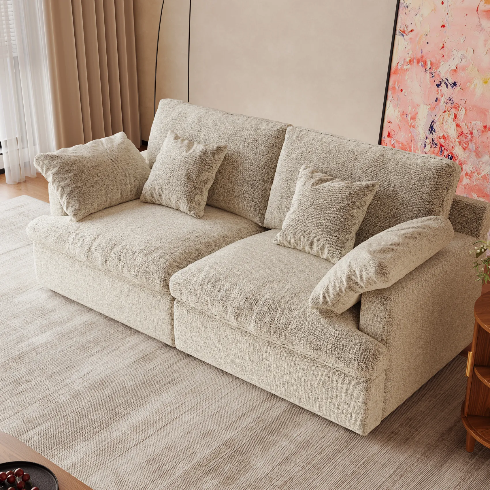 Compact light beige modular sofa with plush pillows, set against a soft-toned interior and large window