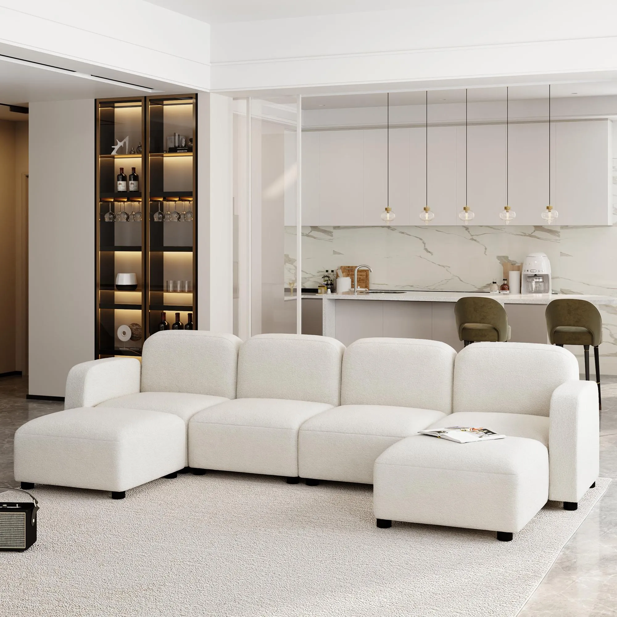 White U-shaped modular couch with chaise lounge in an open-concept living space, styled with a plush carpet and a view of the modern marble kitchen