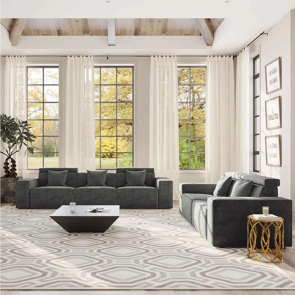 Spacious living room with charcoal grey modular deep-seat sofas arranged around a geometric rug and large windows with sheer curtains