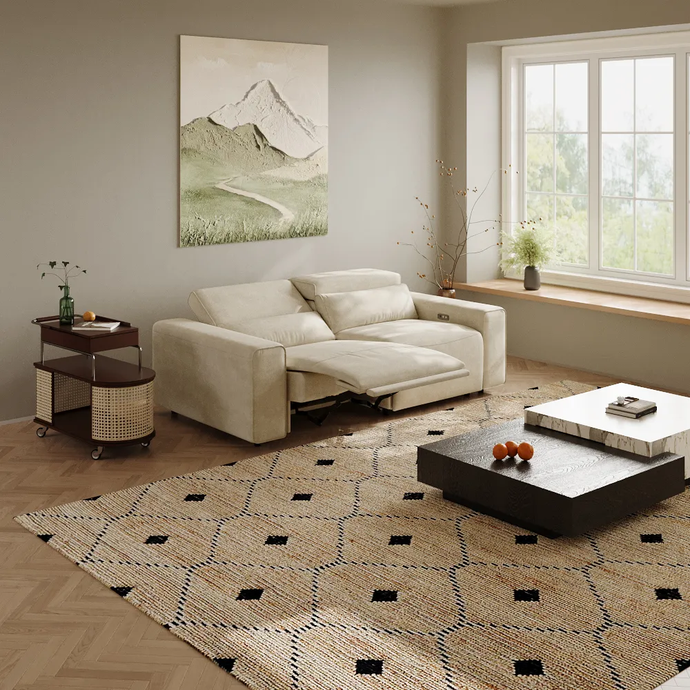 Modern beige reclining sofa in a cozy living room with mountain wall art, rattan side table, and large window seating.