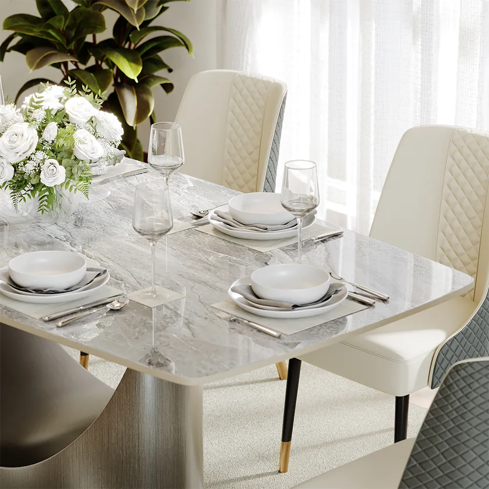 Elegant gray sintered stone dining table set with cream quilted chairs and minimalist tableware in a bright dining room.