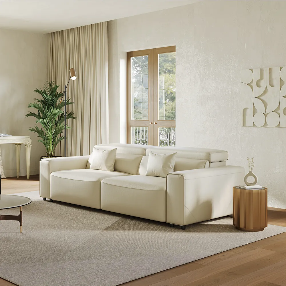 Modern cream modular sofa with adjustable headrests and chaise extension, styled in a bright living room with neutral tones and large windows.