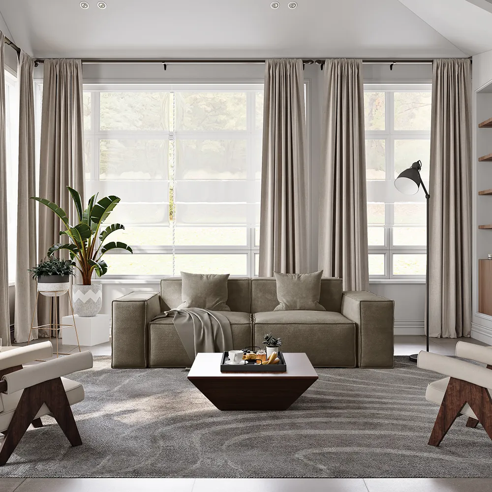 Contemporary taupe sofa with boxy arms and minimalist cushions, placed in a bright living room with tall windows, layered curtains, and a geometric coffee table