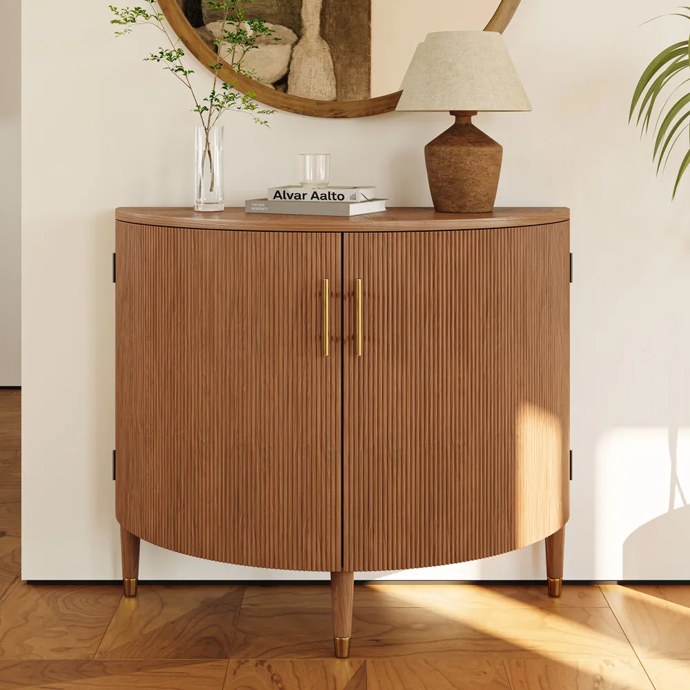 Mid-century modern tambour door cabinet with curved edges and fluted wood detail, styled with a ceramic lamp and decorative book in a cozy entryway.