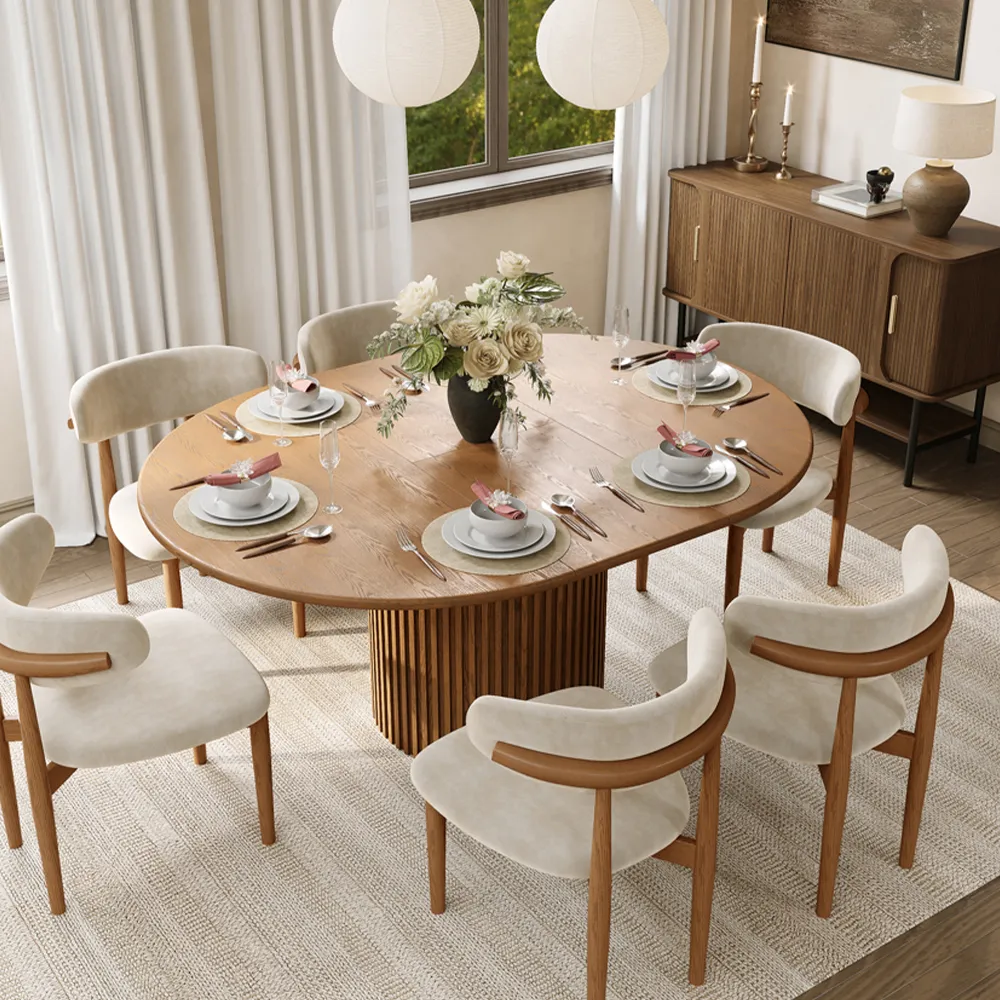 Mid-century modern walnut extendable dining table set with fluted pedestal base and six cream upholstered chairs in a bright dining room