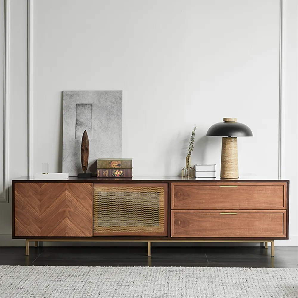 Mid-century modern sliding TV stand with herringbone doors and brass accents against white wall