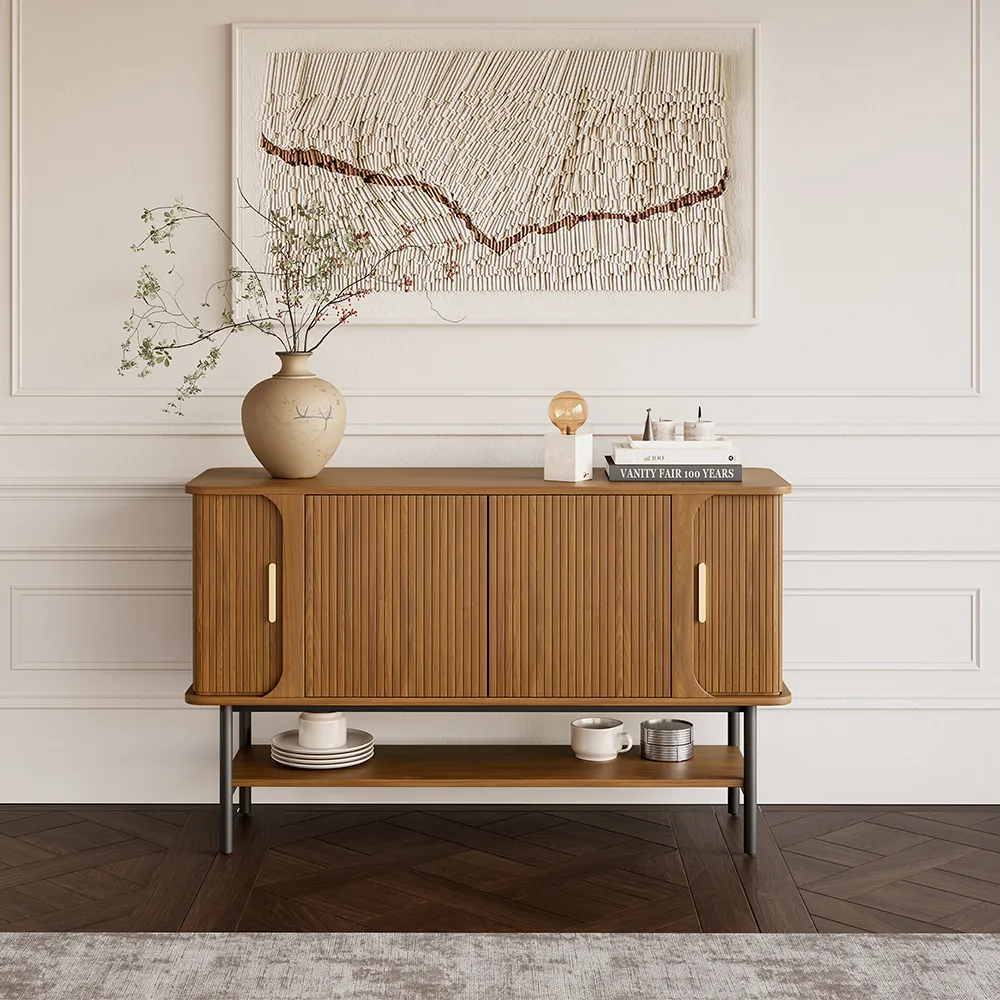 Mid-century modern wood sideboard with fluted doors and open bottom shelf, styled with vase and art on a white paneled wall.