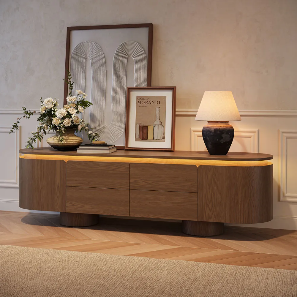 Mid-century modern TV stand with extra-large rounded cylinder legs, styled with neutral-toned art, dried grass, and ceramic lamp for a minimalist living room look.