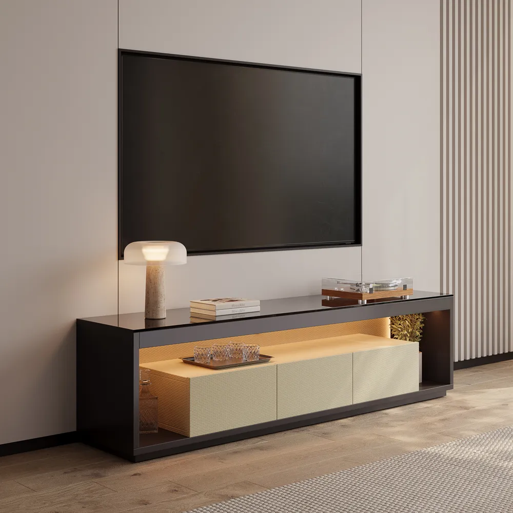 Sleek black-framed TV console with beige storage drawers, glass tabletop, and built-in warm lighting, styled with books and accessories in a modern living room.