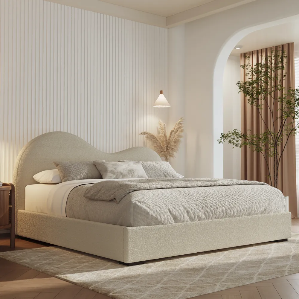 Curved cloud-shaped headboard boucle bed in a minimalist bedroom with warm neutral tones and soft lighting