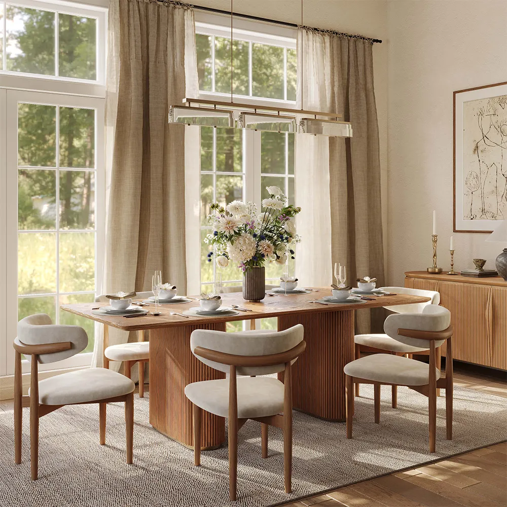 Mid-century modern round dining table with white sintered stone top and fluted walnut pedestal base, surrounded by curved wood dining chairs in a natural light-filled space.