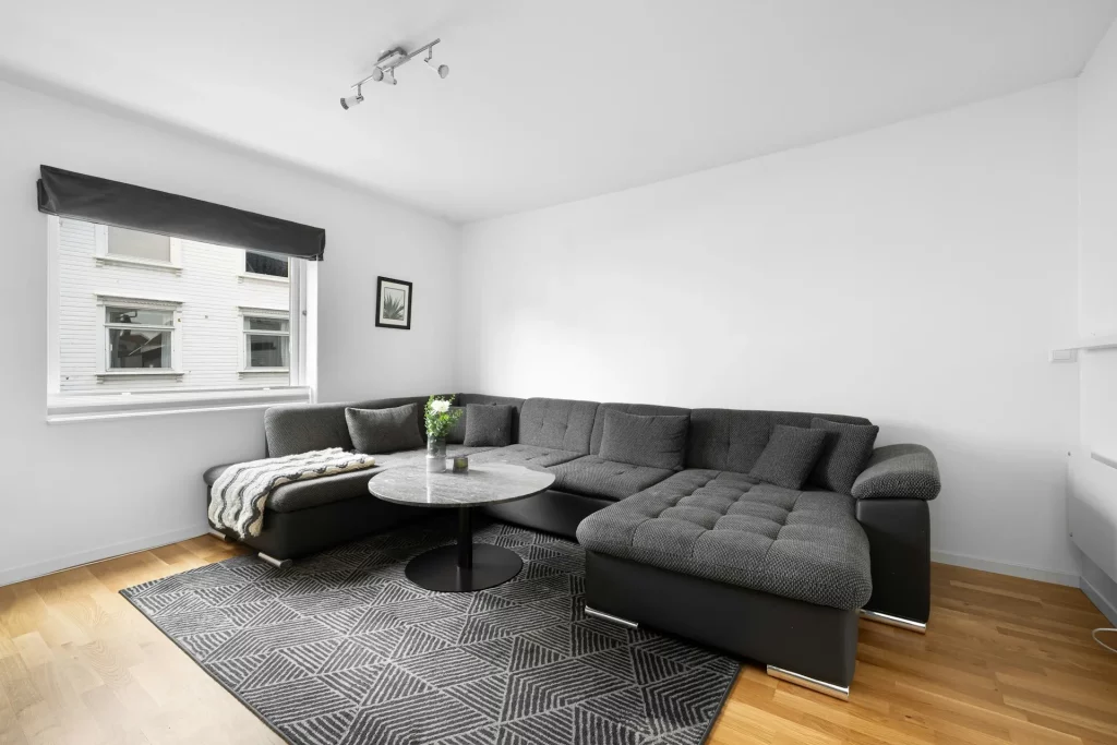 Grey Sofa Living Room Ideas Featuring a Dark Grey Sectional with a Textured Throw Blanket And Patterned Grey Rug