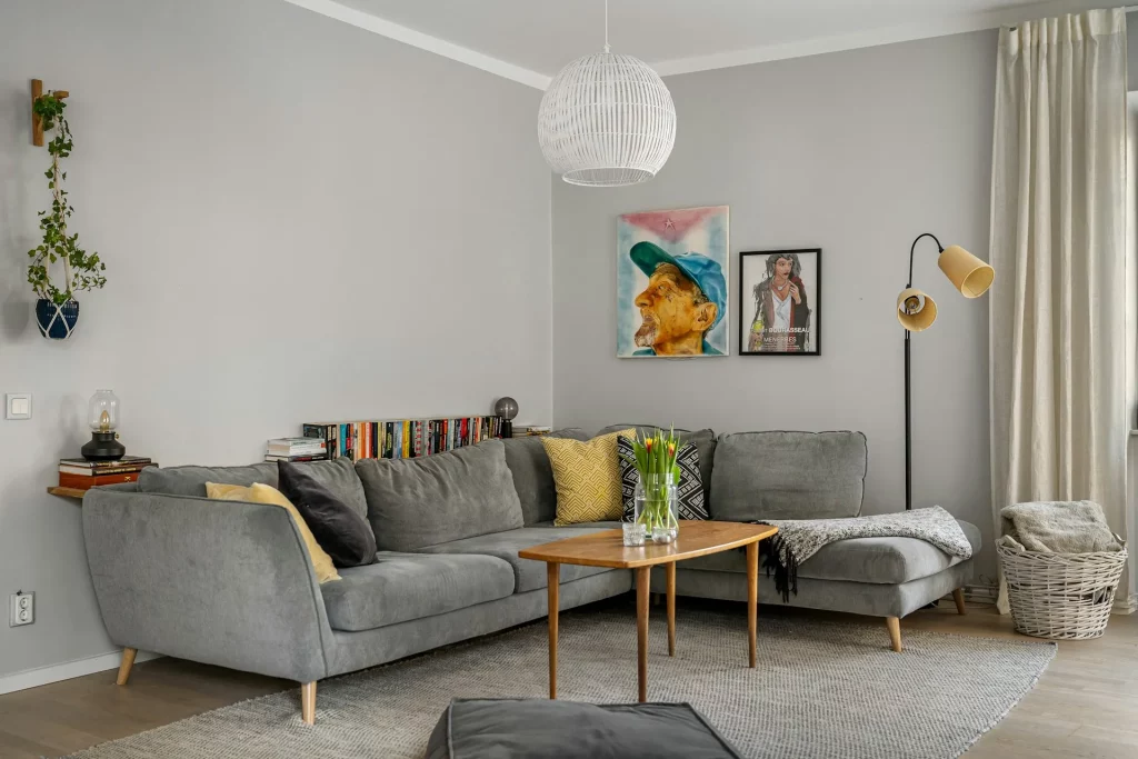 Grey Sofa Living Room Ideas With Colorful Paintings, Floor Lamp, and Woven Basket