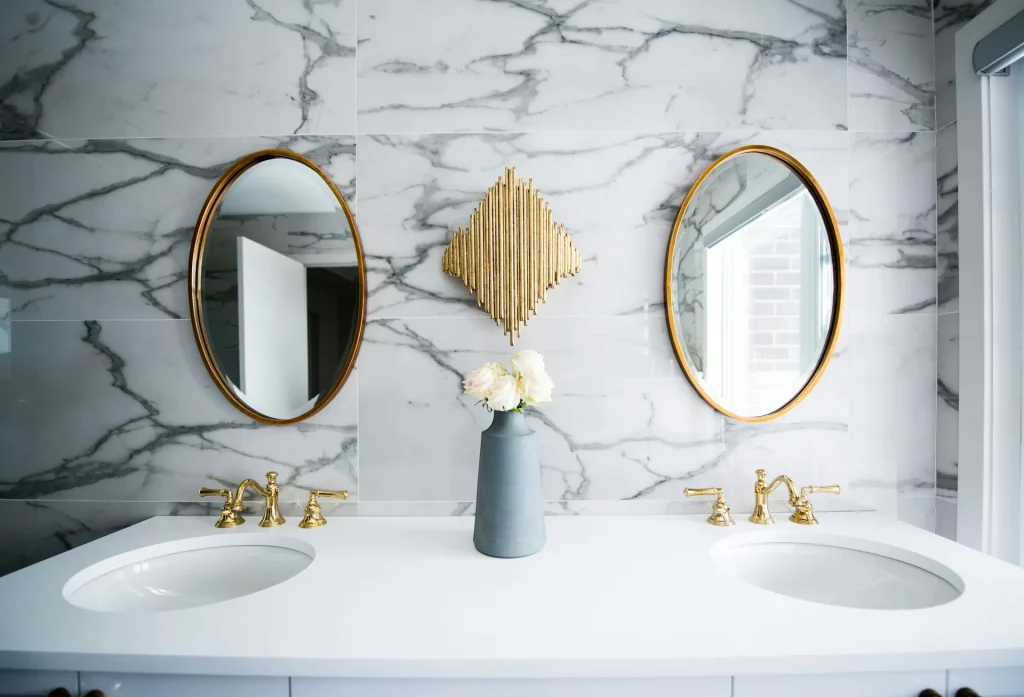 Mid Century Modern Bathroom Ideas Showcasing Symmetrical Double Mirrors, Gold Faucets, and Marble Finishes