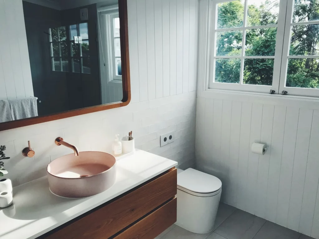 Mid Century Modern Bathroom Ideas with a Soft Pink Sink and Natural Wood Vanity