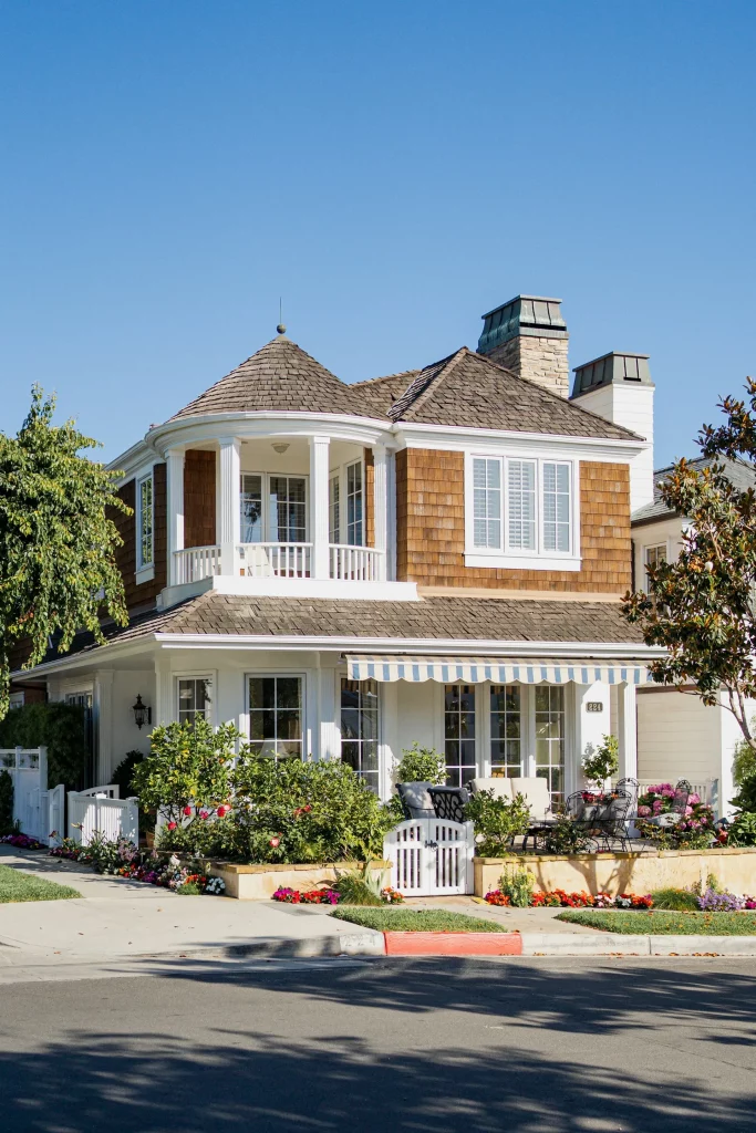 Mid Century Modern Brick Exterior Home with Warm Brown Shingles, White Columns, and Large Windows