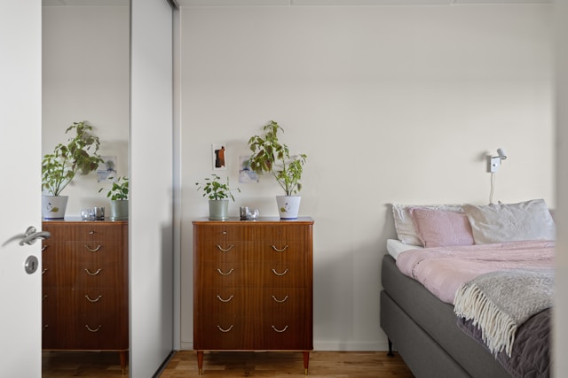 A bedroom with a bed, dresser and mirror