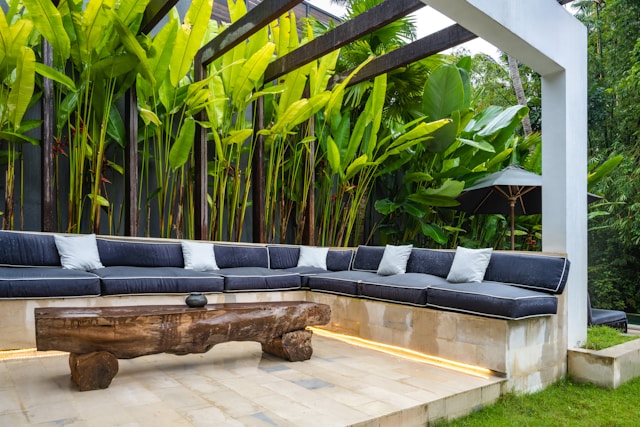 A outdoor couch sitting on top of a wooden platform