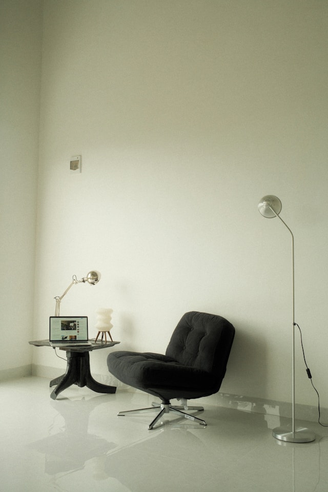 Cozy lounge chair in a bright home office corner with laptop and side table