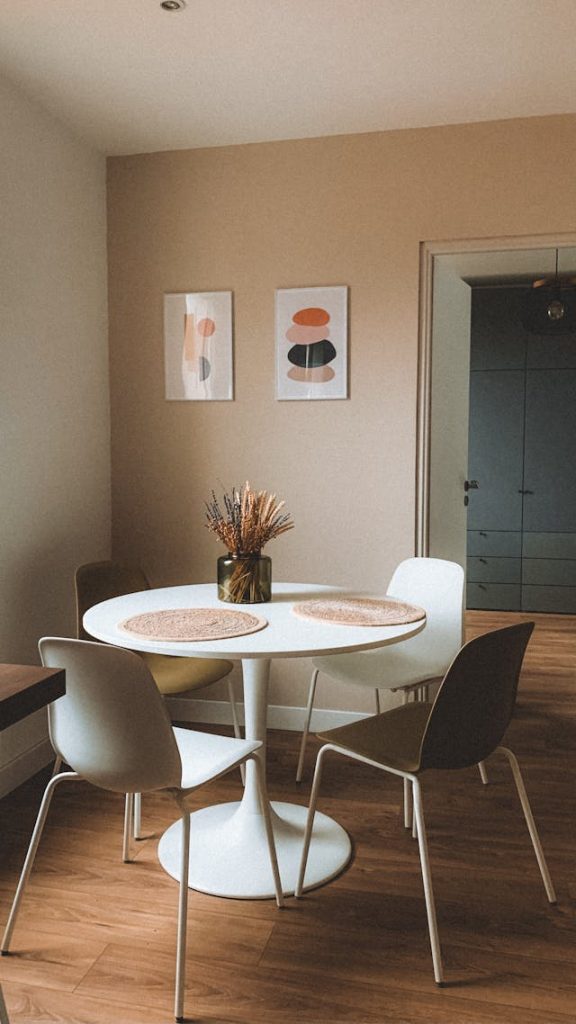 Modern minimalist dining room with white chairs and chandelier