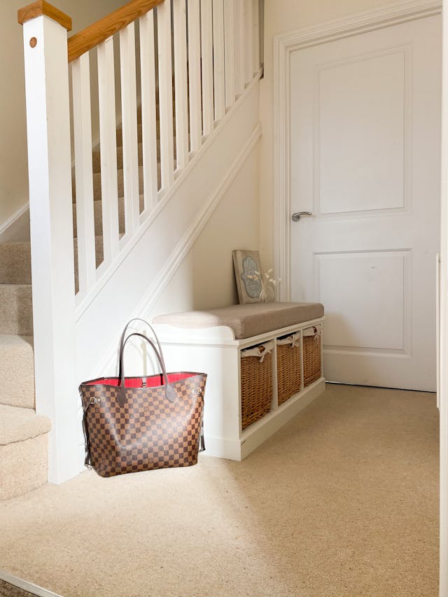 Storage Bench with Wicker Basket Against a Staircase Wall