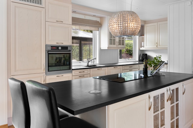 Traditional style kitchen with cream cabinets and black countertop island
