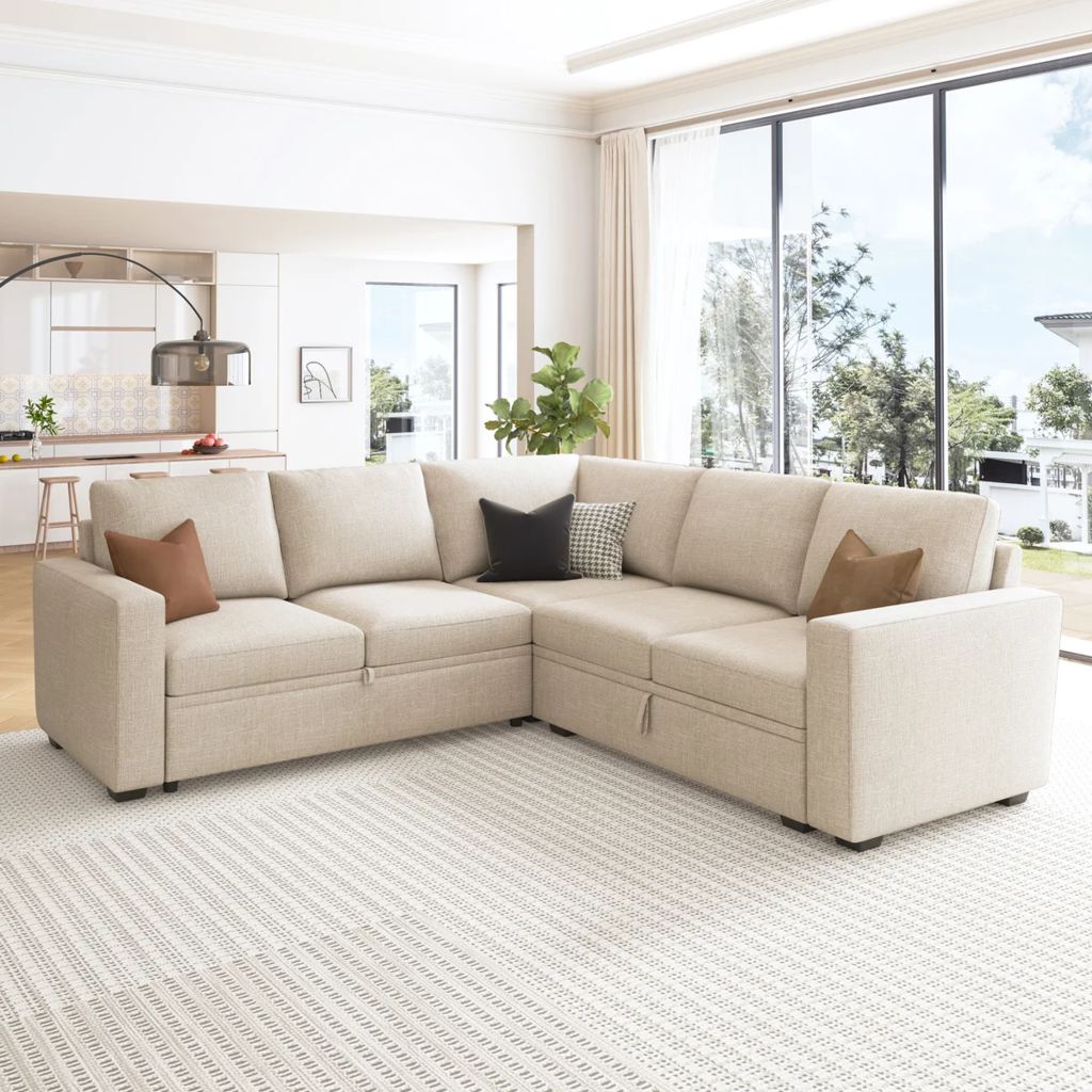 Beige L-shaped modular sleeper sectional with hidden storage in a bright modern living room.