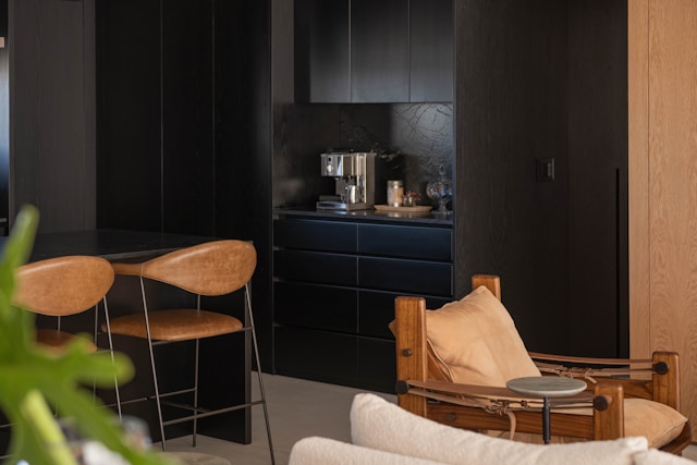 A modern kitchen with leather chairs