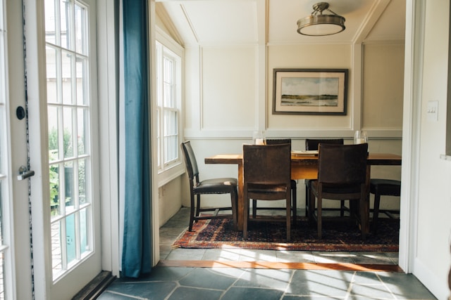 rectangular wooden dining table near door in bright interior