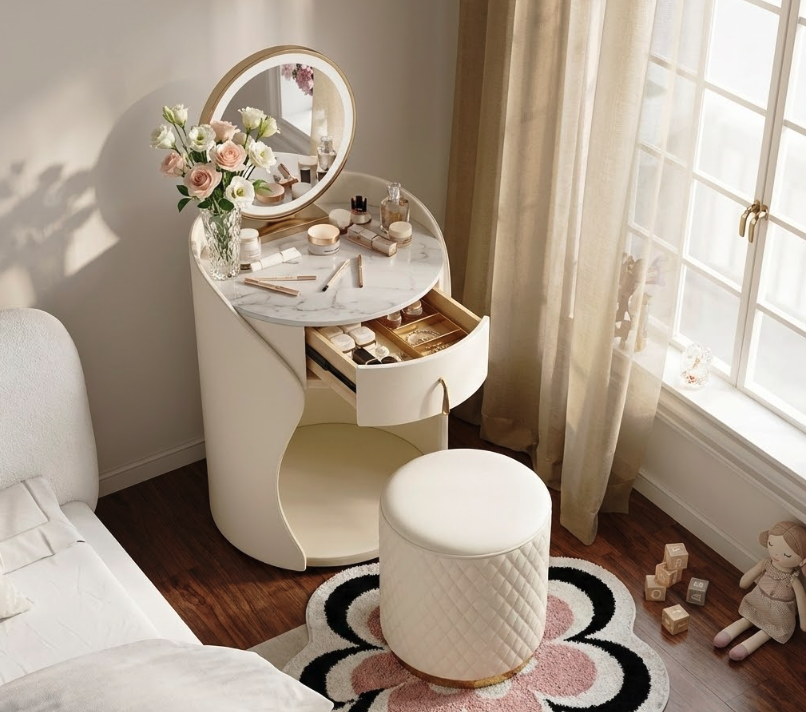Luxurious cream rounded makeup vanity with marble countertop, gold-accented round LED mirror, open drawer organizer for jewelry and cosmetics, fresh roses, and quilted stool – premium choice in makeup vanity buying guide.