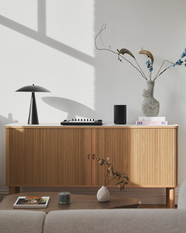 Modern wooden sideboard with decorative items and lamp